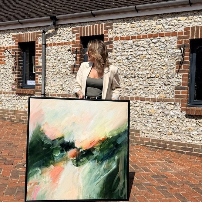 Joanna Gilbert holding Aura, original abstract painting in a black float frame