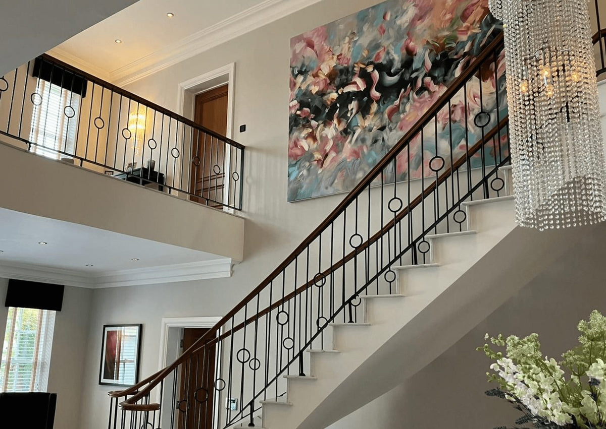 A large pink and teal abstract commission by Joanna Gilbert on a double-height staircase wall