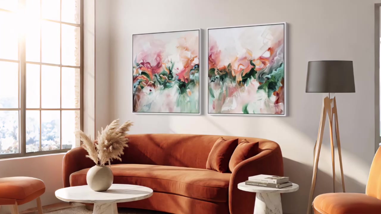 Pair of abstract prints in green and pink above an orange velvet sofa