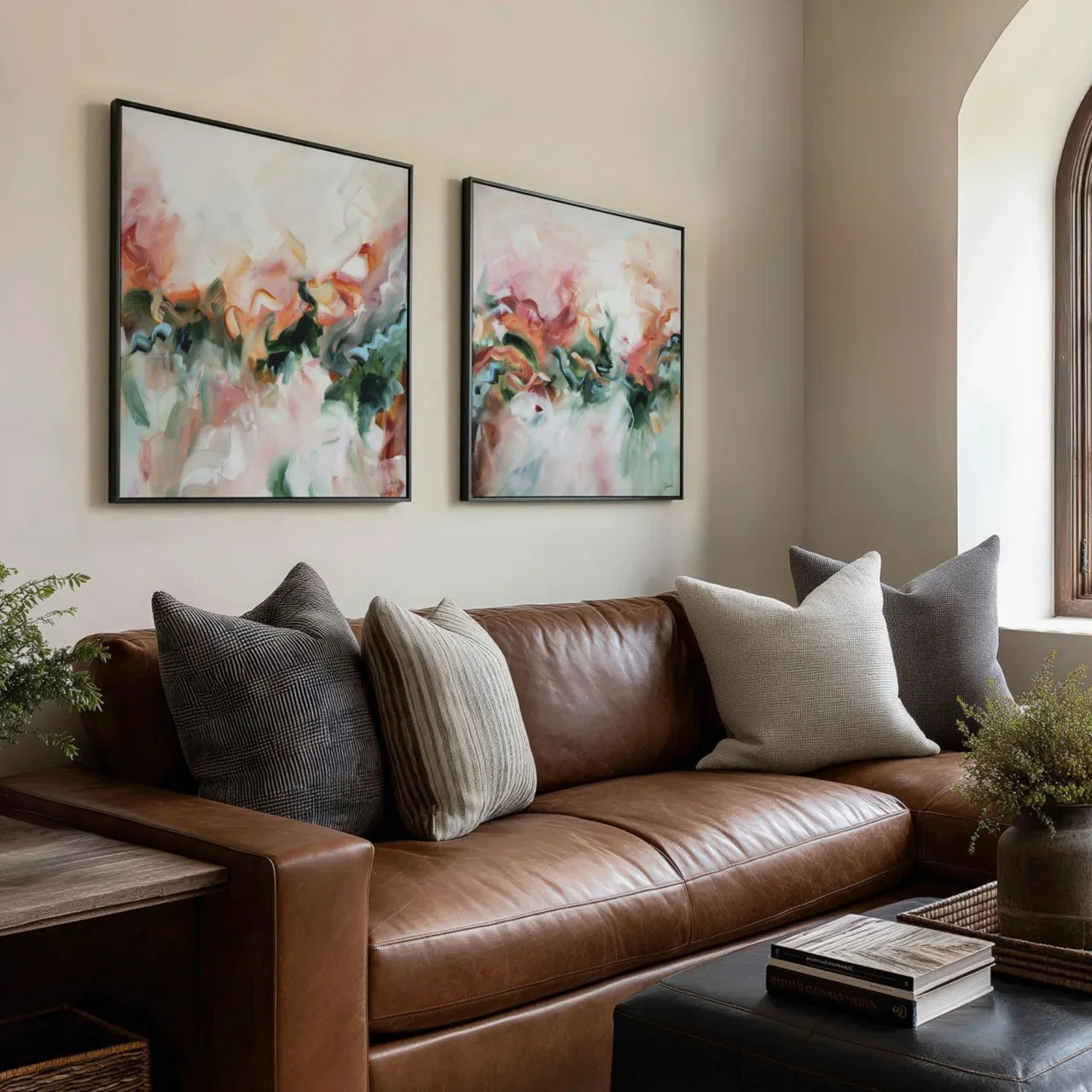 Brown leather sofa with decorative pillows in a living room setting with abstract wall art.